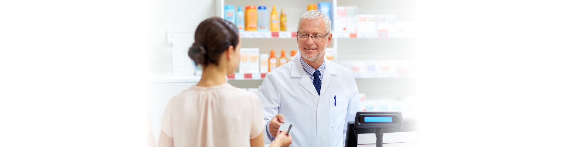 young woman talking to an elderly pharmacist